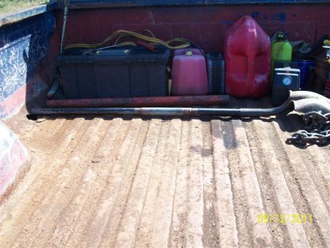 1979 Ford F-150 - The interior of a truck bed holds various items including gas cans, a battery, and tools.