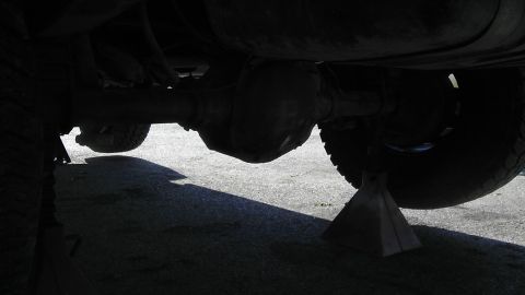 1989 Ford Bronco - Undercarriage view showing the rear axle and differential assembly, with tires visible on jack stands.