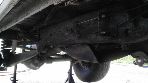1989 Ford Bronco - Close-up of the undercarriage of a 1989 Ford Bronco, highlighting its frame and suspension components.