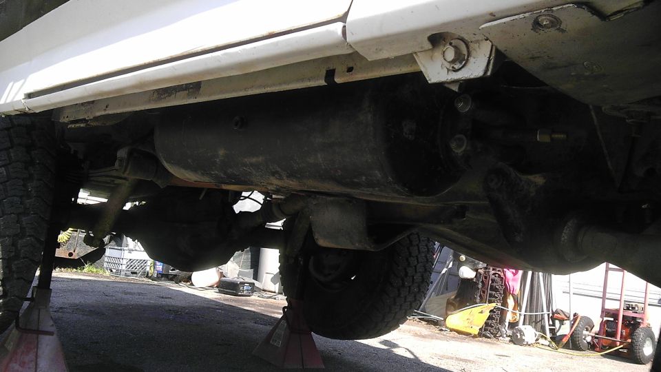 Undercarriage of a 1989 Ford Bronco showing the rear axle and fuel tank