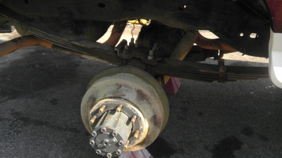 Rear axle assembly with leaf springs and brake drum visible