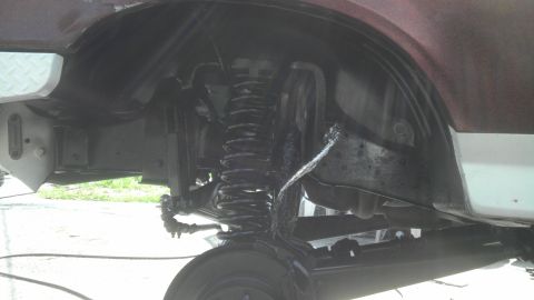 1989 Ford Bronco - Close-up view of the front suspension and wheel well area of a 1989 Ford Bronco.