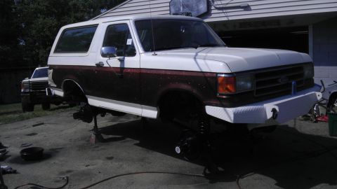1989 Ford Bronco - This two-tone Ford Bronco is raised on jack stands, with its wheels removed for maintenance.