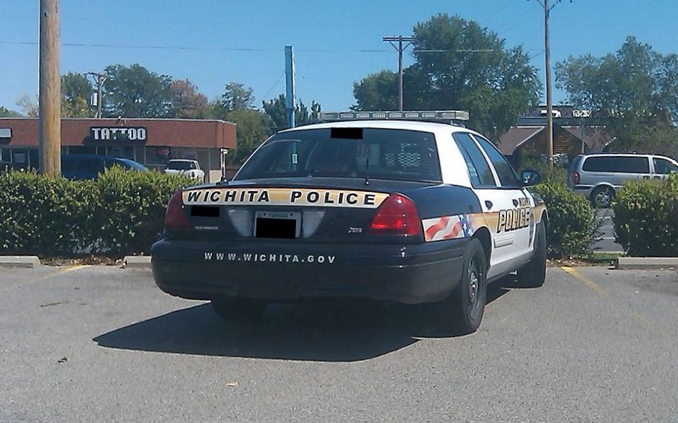 Rear view of a black and white police car with "WICHITA POLICE" on the trunk