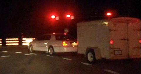 2000 Mercury Grand Marquis - White 2000 Mercury Grand Marquis is seen from behind while towing a trailer at night.