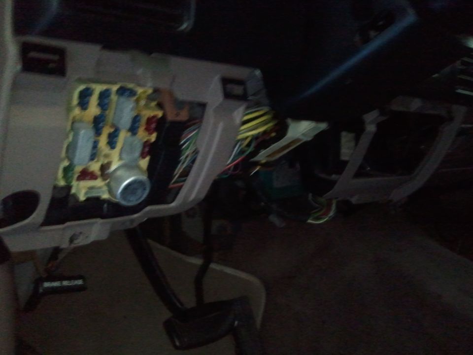 Fuse box with blue and yellow fuses, and exposed wiring