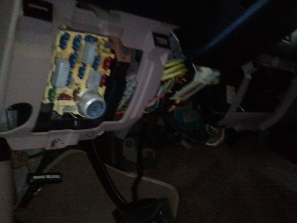 Fuse box and wiring under dashboard. Some fuses are blue, red, and gray