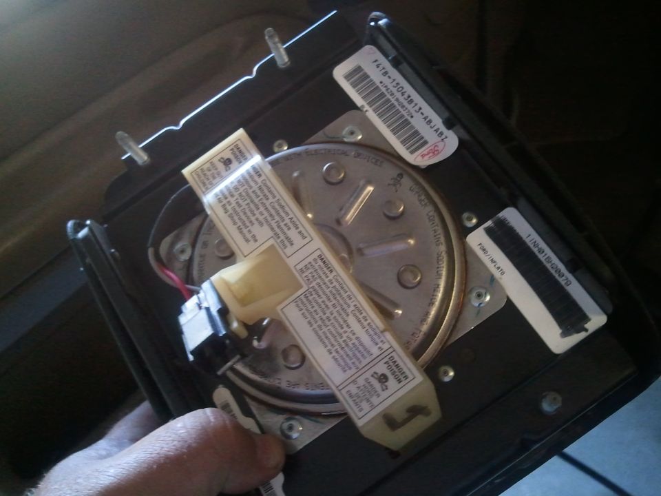 Clock spring part with warning labels and Ford part numbers