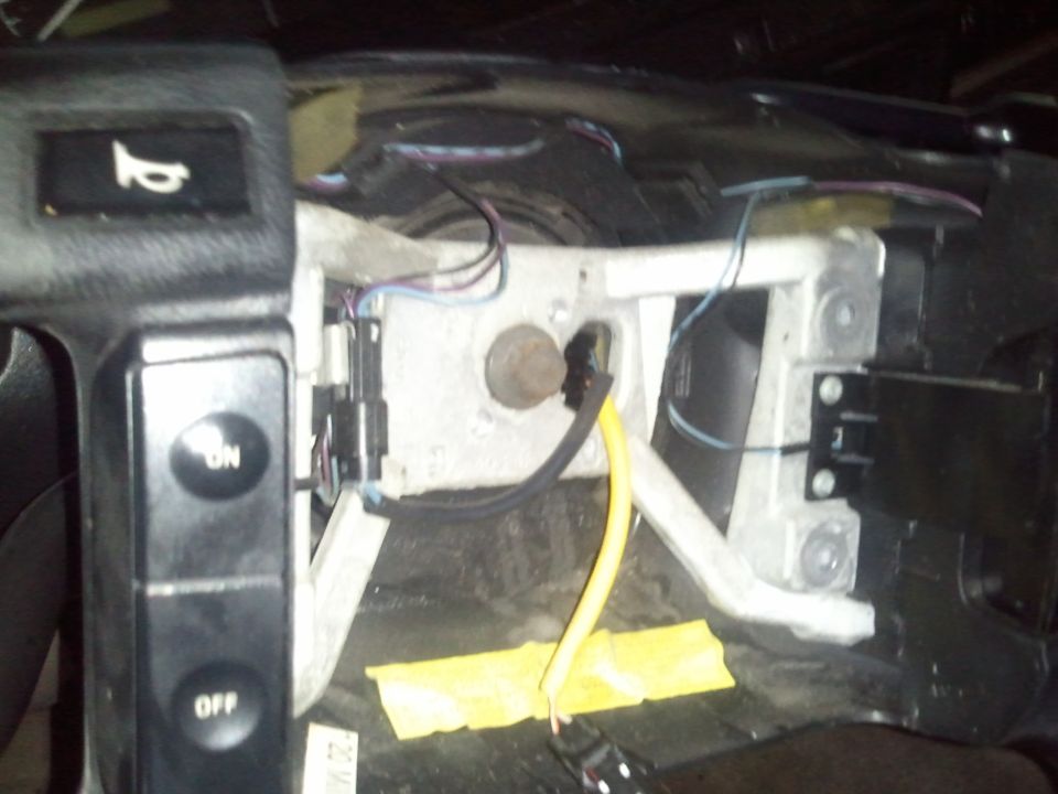 Dashboard wiring with ON/OFF buttons and a horn symbol. Yellow tape secures some wires