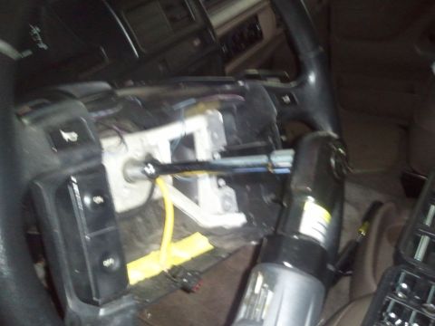 1994 Ford Bronco - Close-up of a vehicle's interior showing the steering column with tools for repair.