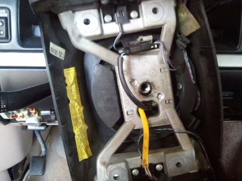 1994 Ford Bronco - Close-up of the steering column assembly in a 1994 Ford Bronco, showing internal components and a warning label.