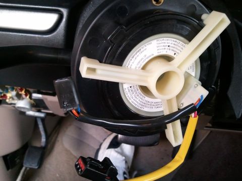1994 Ford Bronco - Close-up of a vehicle's clock spring assembly, showing electrical connectors and wiring.