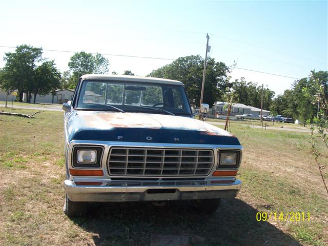 Front view of a 1979 Ford F-150 with a blue hood and white cab