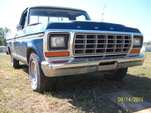 1979 Ford F-150 - A blue Ford pickup truck is parked outside on a sunny day. The grille and headlights are visible.