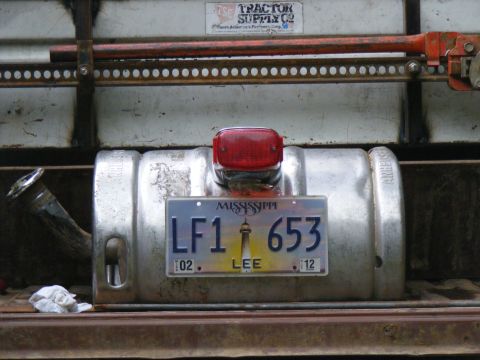 1978 Ford Bronco - A close-up view of a fuel tank, a Mississippi license plate and a red taillight, mounted on a vehicle.