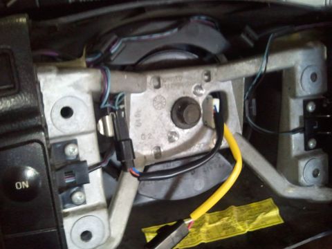1994 Ford Bronco - Close-up view of a steering column clock spring assembly, showing wiring and an "ON" button.