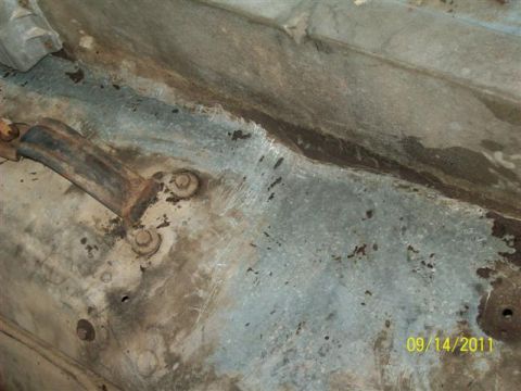 1979 Ford F-150 - A close-up view of a rusty bracket attached to the undercarriage of a vehicle.