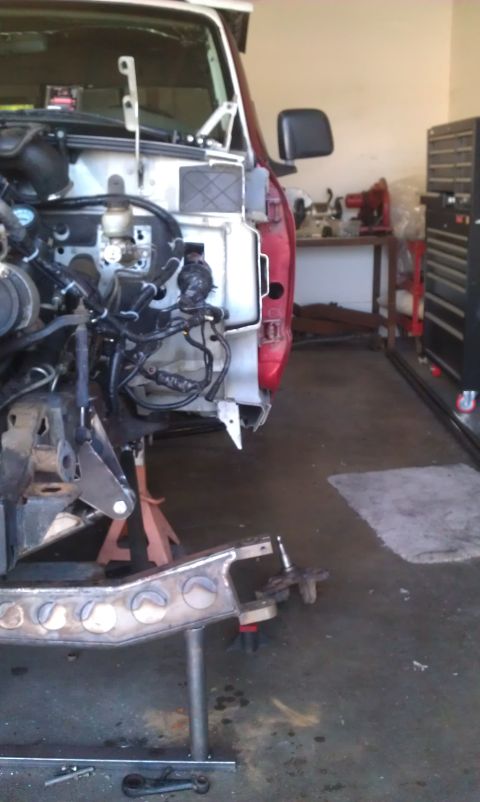 1992 Ford Ranger - Front end of a red truck disassembled for repair or modification, revealing engine and chassis details.