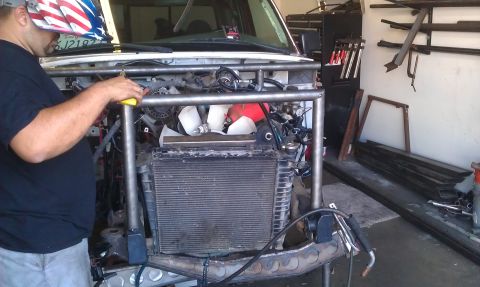 1992 Ford Ranger - A person is fabricating a custom roll cage onto the front of a vehicle in a workshop setting.
