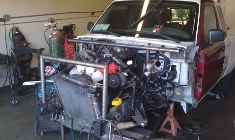 1992 Ford Ranger - This truck is undergoing significant modifications, with its front end disassembled and a custom roll cage being fitted.