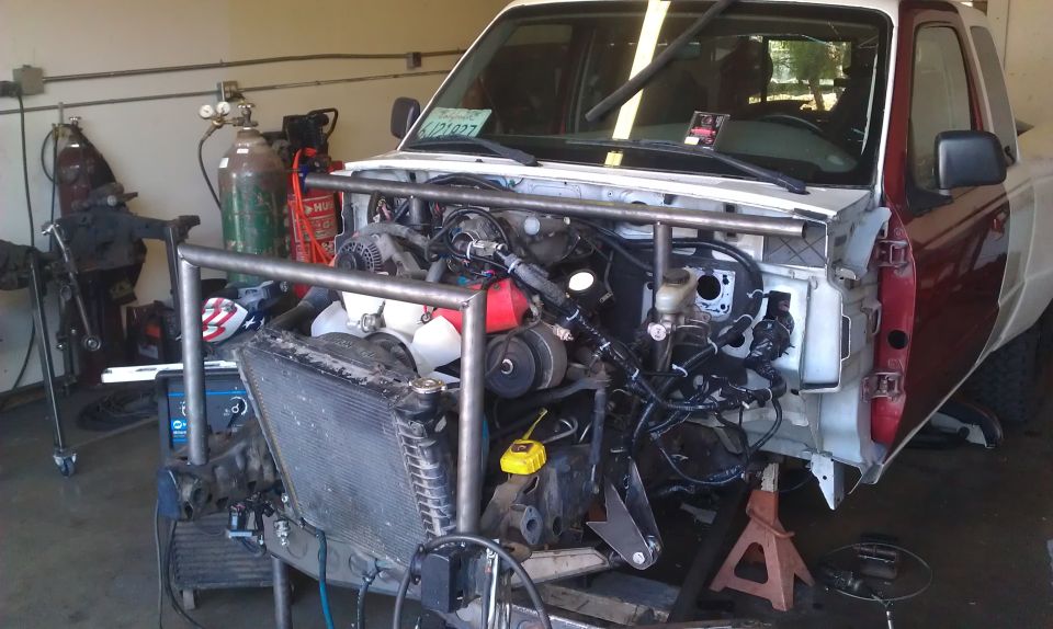 Truck front end removed, roll cage installed, engine exposed