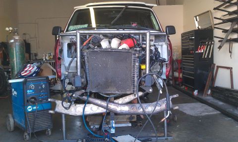 1992 Ford Ranger - Vehicle front end undergoing modifications in a workshop with welding gear and spare parts visible.