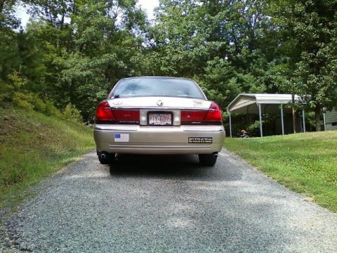2000 Mercury Grand Marquis - Rear view of a 2000 Mercury Grand Marquis parked on a gravel driveway.