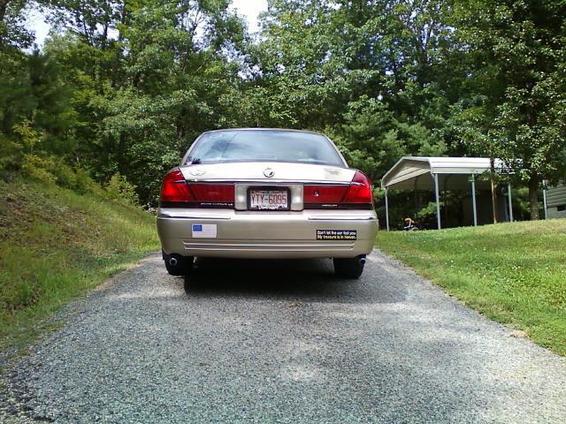 2000 Mercury Grand Marquis rear view, gold paint, license plate YTY-6095, with a "Don't let the car fool you..." sticker