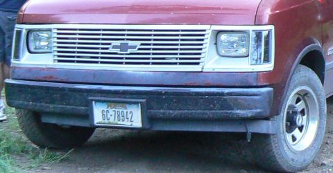 2006 Ford E350 - This Chevrolet van features a distinctive chrome grille and a front bumper with a license plate.
