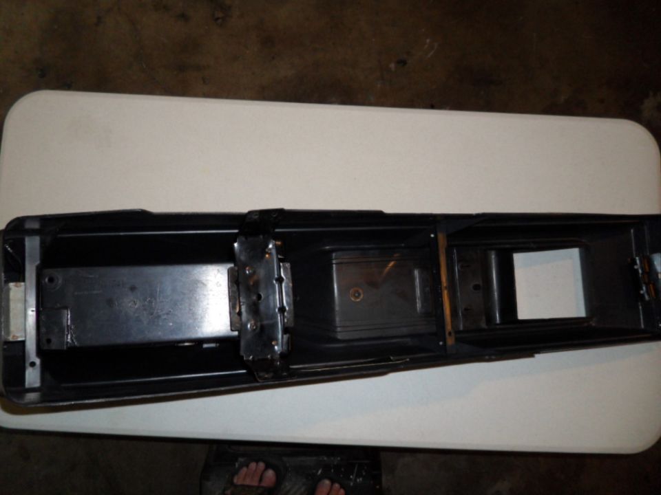 Black car part with metal brackets and compartments