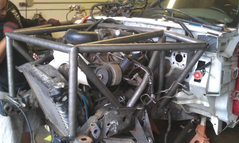 1992 Ford Ranger - A custom roll cage is being installed in the engine bay of a vehicle, possibly a 1992 Ford Ranger.