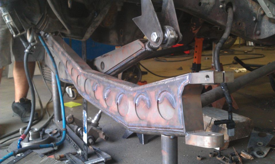 Custom metal fabrication for vehicle suspension, possibly part of a frame modification