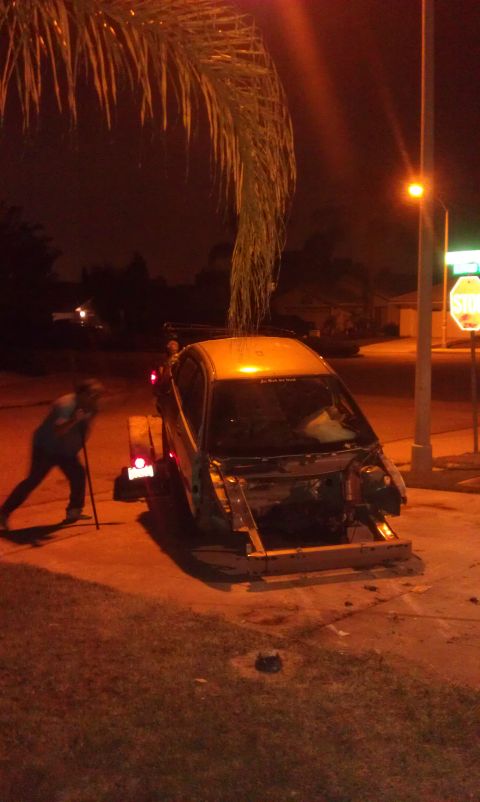 1992 Ford Ranger - A car chassis is being loaded onto a trailer at night, with a person assisting.