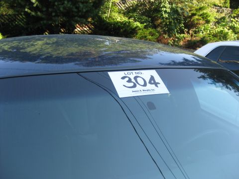 2003 Ford Crown Victoria - Auction lot number 304 is displayed on the windshield of a car, with another vehicle partially visible.