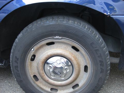 2003 Ford Crown Victoria - Close-up of a blue 2003 Ford Crown Victoria's front wheel, Eagle Ultra tires and a Ford center cap.