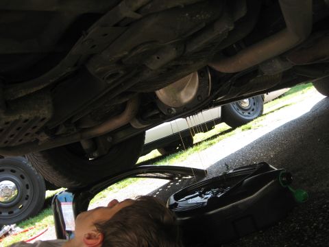 2003 Ford Crown Victoria - Oil drains from the differential of a 2003 Ford Crown Victoria into a collection pan during maintenance.