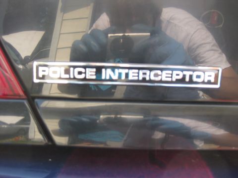 2003 Ford Crown Victoria - A 'Police Interceptor' badge is visible on the trunk of a dark-colored vehicle.