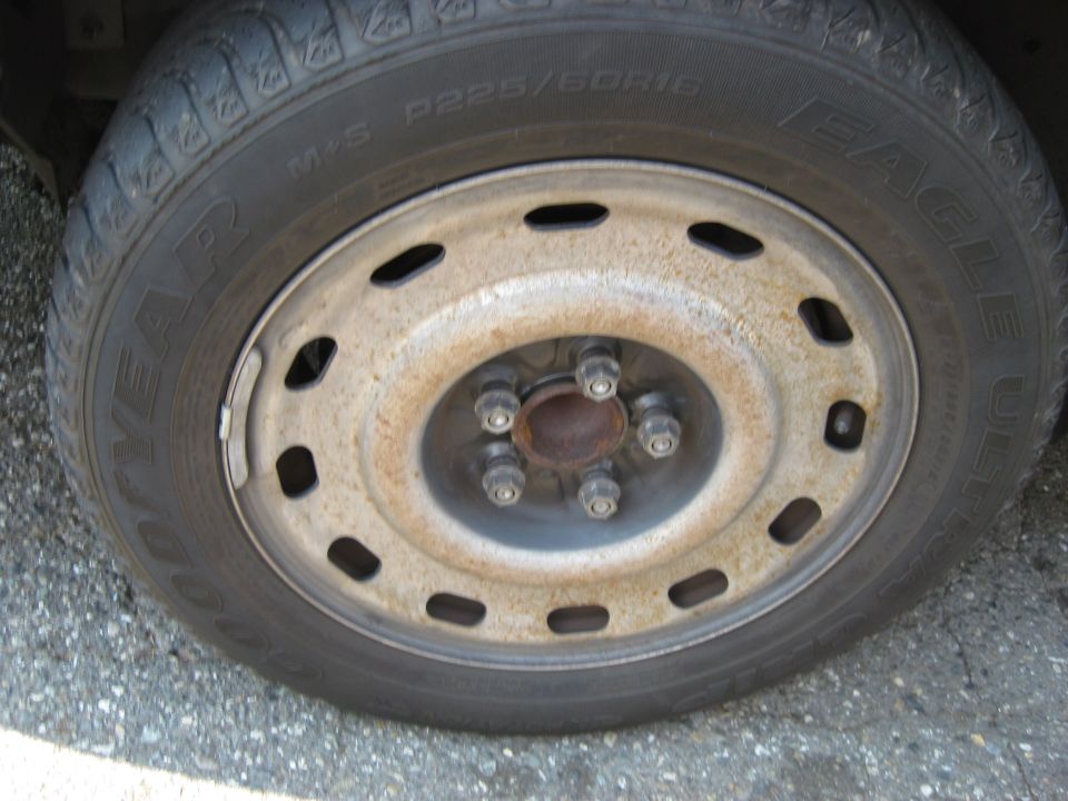 Close-up of a Goodyear Eagle tire on a steel wheel with five lug nuts