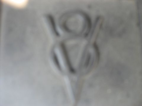 2003 Ford Crown Victoria - A V8 engine emblem is visible on a gray surface, with a website address at the bottom right.