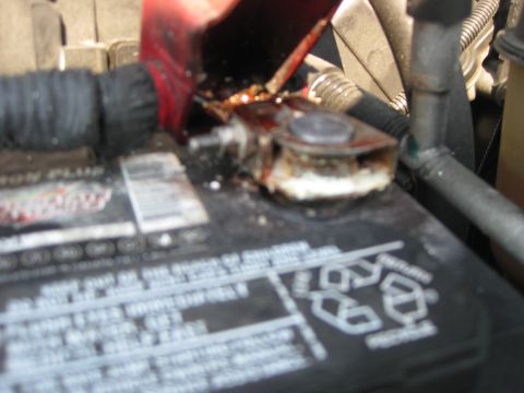 2003 Ford Crown Victoria - Close-up of a corroded battery terminal, indicating potential maintenance issues.