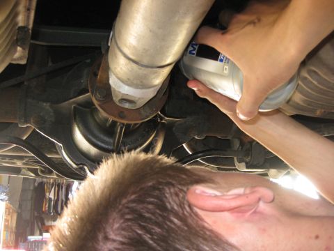 2003 Ford Crown Victoria - Someone is changing the oil filter on a vehicle, with a SuperMotors.net watermark visible.