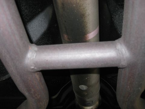 2003 Ford Crown Victoria - Close-up of a vehicle's undercarriage, focusing on the exhaust pipes and a connecting crossbar.
