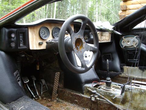 2000 Ford E350 - Interior view of a car with custom steering wheel and gauges, showing signs of wear and tear.