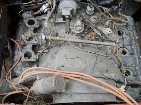2000 Ford E350 - Close-up view of a dirty and corroded engine, showing spark plug wires and distributor.