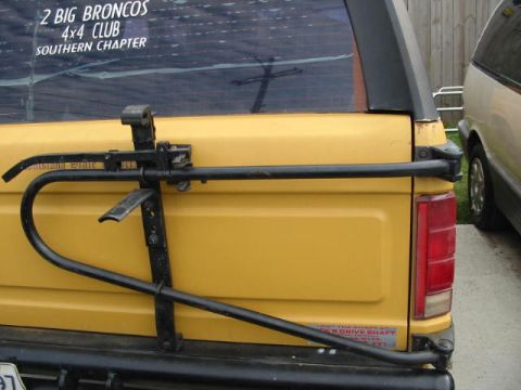 1986 Ford Bronco - Rear view of a yellow 1986 Ford Bronco, equipped with a Hi-Lift jack and a sticker for '2 Big Broncos 4x4 Club Southern Chapter'.