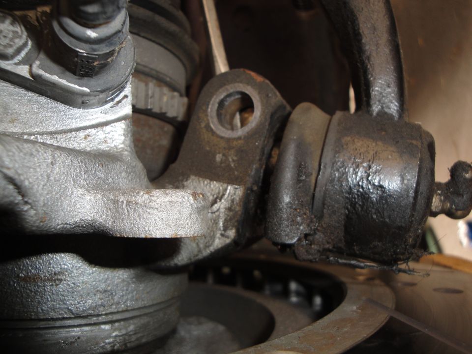 Close-up of a worn suspension bushing and metal bracket