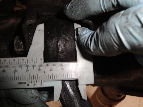 1995 Ford Taurus - Close-up of a caliper measuring a black rubber bushing, likely part of a vehicle's suspension system.