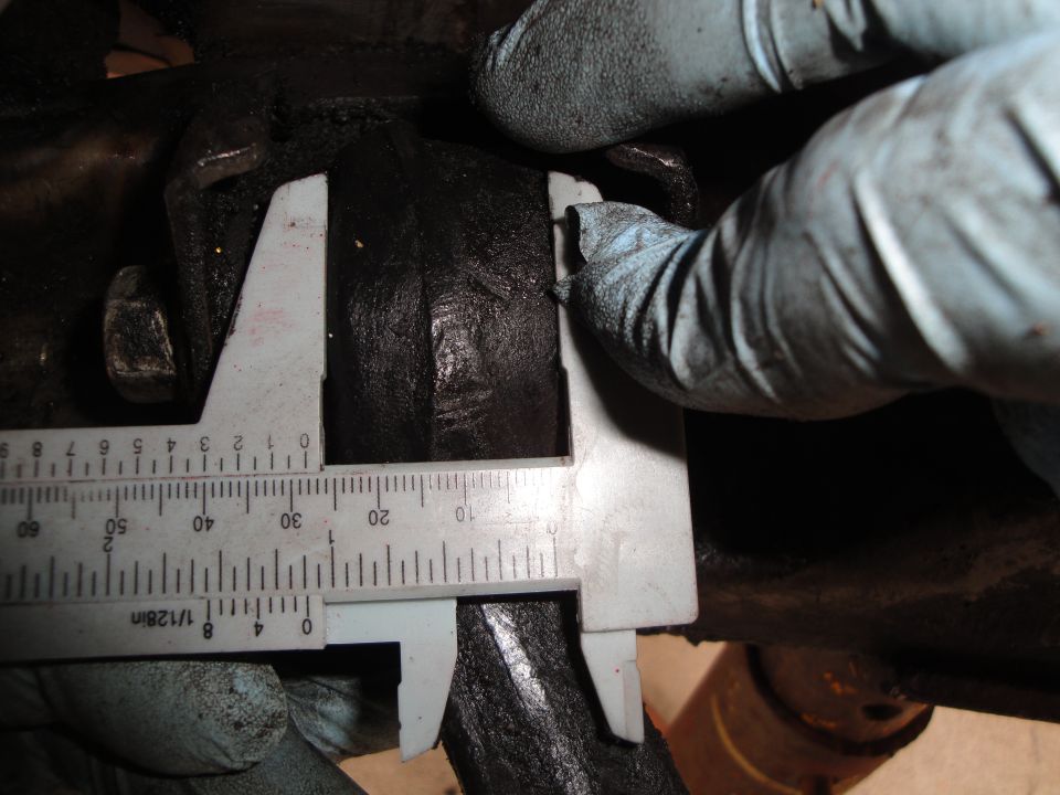 Caliper measuring black rubber bushing on subframe