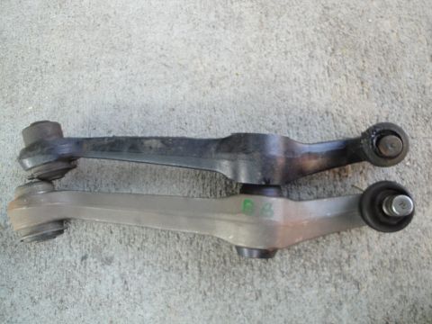 1995 Ford Taurus - Comparison of two automotive control arms, one black and one silver, with visible green markings on the silver part.