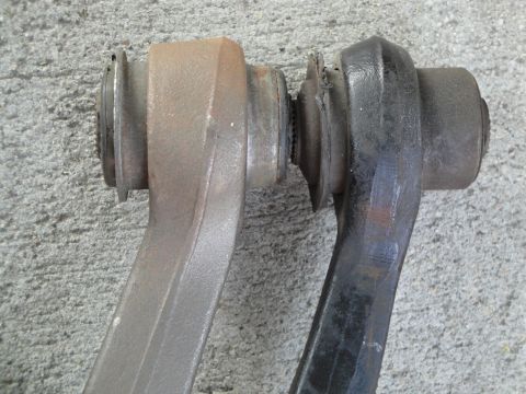 1995 Ford Taurus - Two suspension control arms are shown side-by-side, one appearing older and rusted, the other painted black.